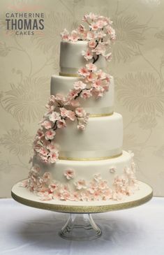 a three tiered wedding cake with pink flowers on it