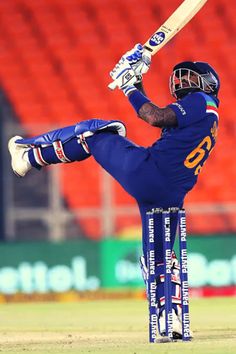 a man in blue uniform playing a game of cricket