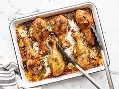 a casserole dish filled with chicken and parmesan cheese, garnished with herbs