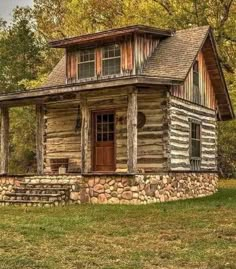 an old log cabin sits in the middle of a grassy area with trees and grass