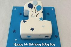 a blue and white birthday cake with balloons