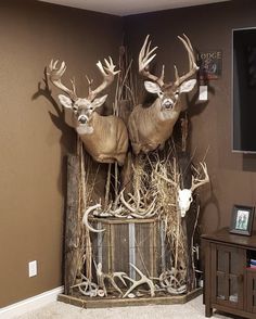 two deer statues sitting on top of a wooden box in front of a flat screen tv