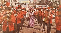 a group of people that are standing in the street with some instruments and marching equipment