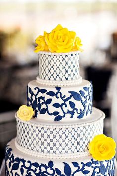 a blue and white wedding cake with yellow flowers