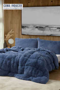 a blue comforter set on a bed in a bedroom