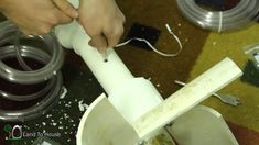 a person using a plunger to make something out of some kind of plastic bottle