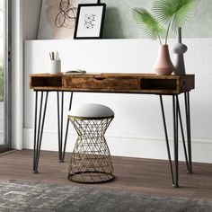 a wooden desk with metal legs and a plant on top in front of a window