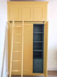 an empty yellow closet with shelves and ladders