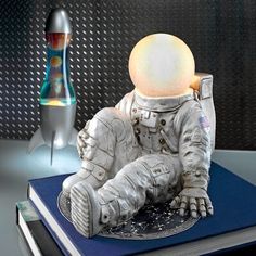 an astronaut figurine sitting on top of a book