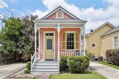 a small pink and white house with yellow trim