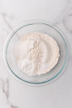 a glass bowl filled with flour on top of a white counter