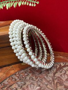 Antique pearl bangle set of 4 , brass made. White Pearl Round Bangle, Pearl Bangle For Wedding, Pearl Bangle As Gift, Elegant Beaded Bangle For Festive Occasions, Silver Pearl Bangle Bracelet For Festive Occasions, Festive Pearl Bangle Jewelry, White Pearl Bangle, Festive Beaded Pearl Bangle Bracelet, Elegant Festive Bangle With Round Beads