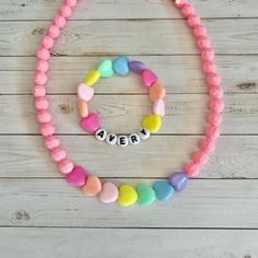 "This is a set of 2! You get a personalized name bracelet with colorful hearts AND the matching pink heart necklace.  This cute pastel, HEART necklace and bracelet set makes a great present for birthdays!  This 15\" stretchy necklace fits right over your head so it's easy to put on- no clasps needed.  🤍 Please check all selections and spelling prior to check out. Our custom jewelry is made to order so all sales are final.  🤍 This set is beautifully packaged and ready to gift. Receipts are neve Playful Heart Beads Jewelry For Birthday, Cute Personalized Heart Bracelet For Birthday, Cute Personalized Heart Bracelet, Sweet Multicolor Heart-shaped Jewelry, Sweet Adjustable Personalized Jewelry, Personalized Pink Jewelry For Friendship, Personalized Adjustable Sweet Style Jewelry, Sweet Personalized Adjustable Jewelry, Custom Name Pink Jewelry For Friendship