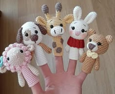 a hand with five crocheted animals on it