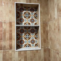 an open window in a tiled wall with decorative tiles on the walls and below it