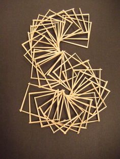 several pieces of toothpicks laid out in the shape of a letter s on a black surface