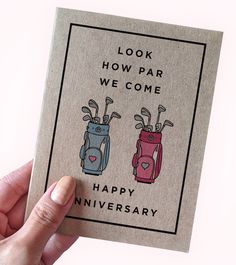 someone holding up a card with two golf bags on it that says, look how far we come happy anniversary