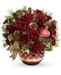 a vase filled with red flowers and christmas decorations