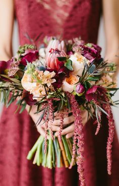 a woman in a red dress holding a bouquet of flowers