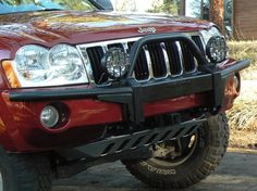 the front end of a red jeep parked in a driveway