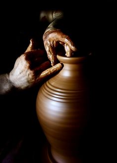 a person is working on a potter's wheel with their hands in the bowl