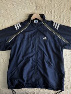 Vintage Adidas lightweight zip up jacket, from the 2000s Vintage Adidas sports jacket in dark blue, green and white detail. Jacket has a zip up front, 2 zipped hand pockets, zippers on the sleeves' hems and the signature Adidas stripes on the shoulders. Jacket has a drawstring on the bottom and a dark blue mesh lining! Size on tag - US S, GB 36 / 38, F 168. Will fit like M for women (model in the photo wears 38 EU/M, 170 cm tall) Please look at measurements below, to see if this jacket will fit 2000s Adidas, Functional Three Stripes Outerwear For Sports Season, Outdoor Long Sleeve Track Jacket With Three Stripes, Winter Sports Outerwear With Three Stripes, Vintage Adidas Jacket, Jacket Vintage, Adidas Zip Up Outfit, Hipster Jeans, Adidas Zip Up