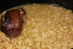 a bowl filled with beans and meat on top of a stove