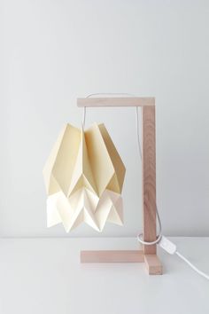 an origami lamp on a wooden stand