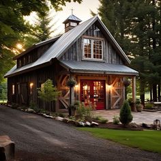 a small house with a red door in the middle of a driveway and trees around it