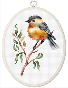 a cross stitch bird sitting on top of a tree branch in front of a white background