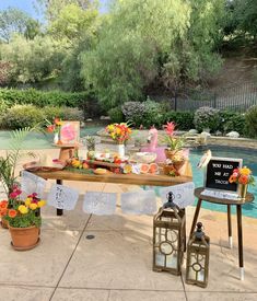 a table with flowers and decorations next to a pool