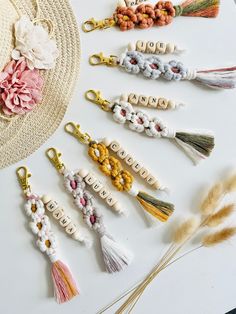 several tasseled keychais are arranged on a table next to a straw hat