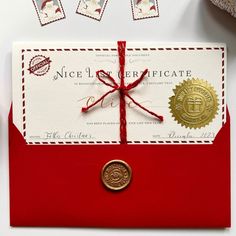 a red envelope with a wax stamp on it and a gold seal attached to the front