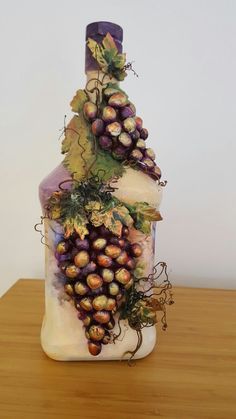 a wine bottle with grapes on it sitting on a table