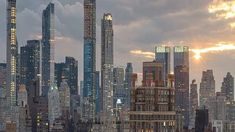 the city skyline is lit up at night, with skyscrapers in the foreground