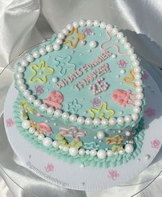 a birthday cake is decorated with pastel colors and pearls