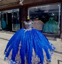 a blue ball gown on display in front of a store