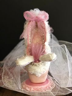 a stuffed animal wearing a pink hat and veil