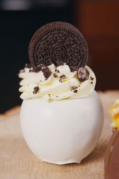 an oreo cookie sitting on top of a white chocolate covered dessert in a bowl