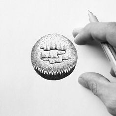 two hands are holding a pencil and drawing an ornament in black and white