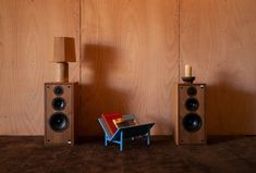 two speakers and a table in front of wooden walls