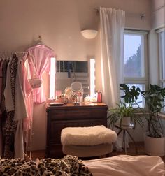 a bedroom with a bed, dresser and mirror in it next to a large window