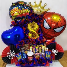 a spiderman balloon bouquet with balloons and confetti