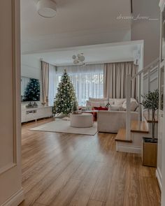 a living room filled with furniture and a christmas tree in the middle of the room