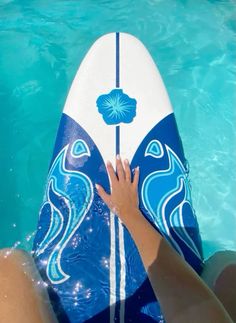 a person is sitting on a surfboard in the water with their hand on it