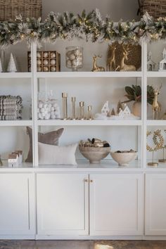 a white book shelf filled with christmas decorations