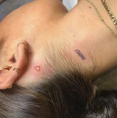 a woman with ear piercings laying on her head next to another person's ear