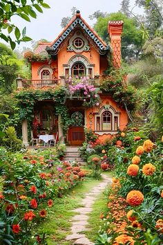 an orange house surrounded by flowers and greenery