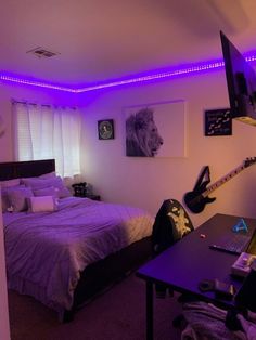 a bed room with a neatly made bed next to a laptop computer and purple lighting