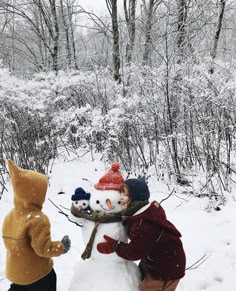 two children are building a snowman in the woods, one is wearing a bear costume